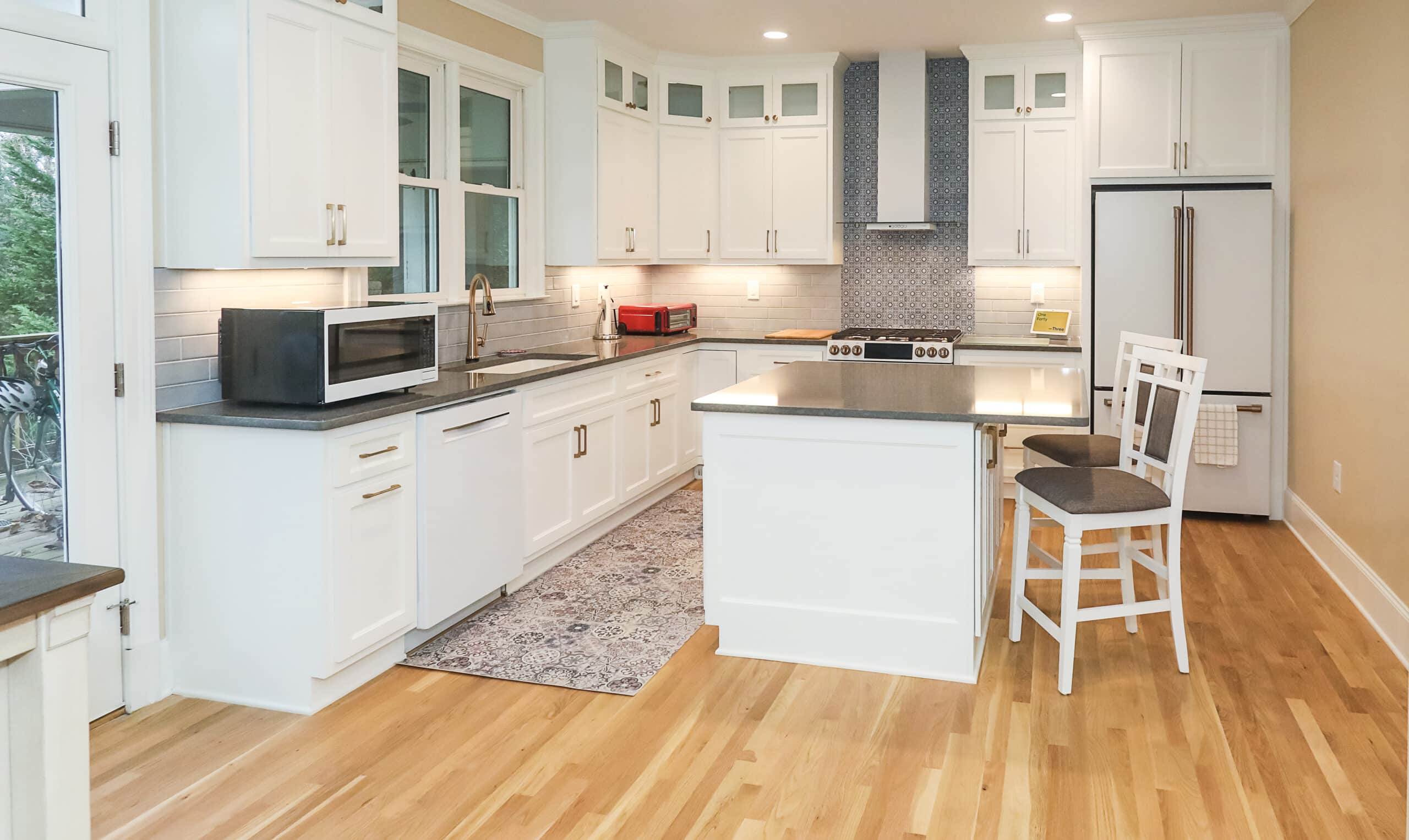 Explore our blog featuring modern kitchen interior designs that showcase white cabinetry, stainless steel appliances, and a central island with seating.