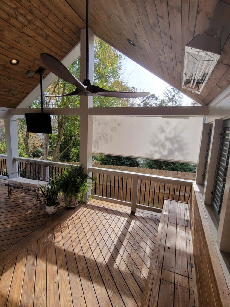 covered porch with large bracing beams and chevron pattern wood stained deck floor